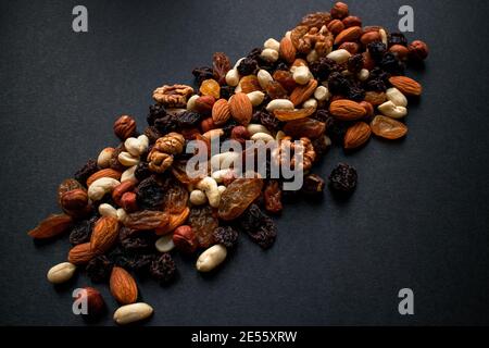 Nuts and dried fruits on a black background. Stock Photo
