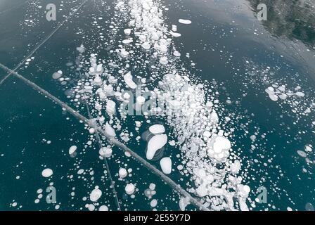 Methane bubbles trapped in the ice on Lake Minnewanka in Banff National Park, Alberta, Canada Stock Photo