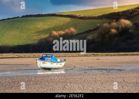 Evening light over a boat moored in the Gannel River at low tide in Newquay in Cornwall. Stock Photo