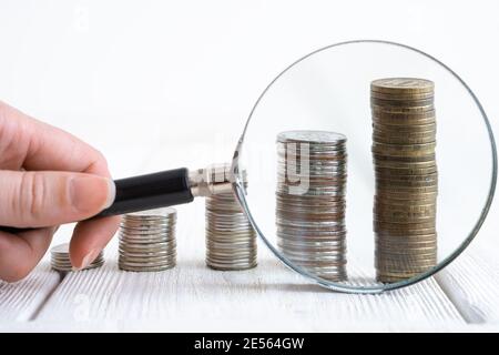 Stacks of coins and unfocused bills in the background. Side view with copy space. Stock Photo
