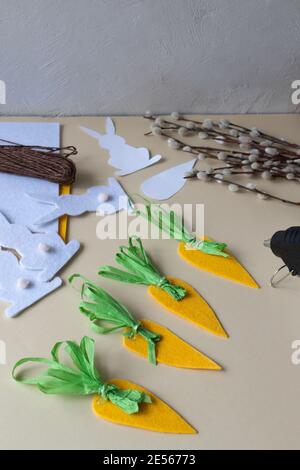 How to make an Easter garland of rabbits and carrots with your own hands from felt. Step by step instruction. Step 8. We make carrot tops out of paper Stock Photo