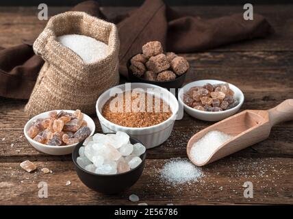 Cane and white sugar in different states on a wooden background. Side view. Stock Photo