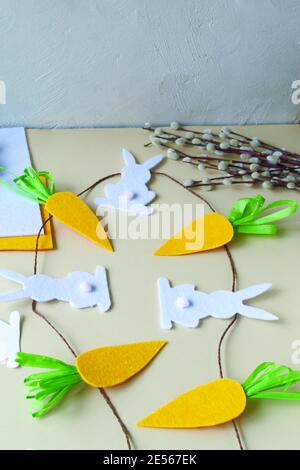 How to make an Easter garland of rabbits and carrots with your own hands from felt. Step by step instruction. Finished garland. Stock Photo