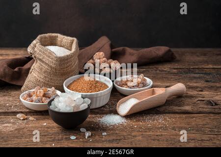 White and cane sugar on a wooden background. Side view with copy space. Stock Photo