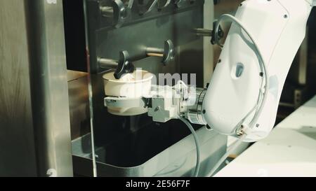 Robot with artificial intelligence making coffee on coffee machine. Close up shot Stock Photo