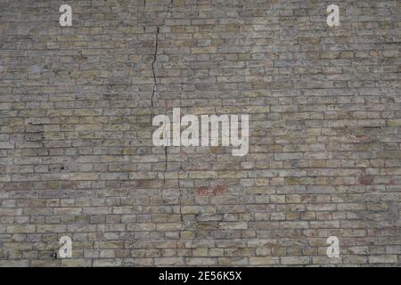Old brick wall with defects and cracks Stock Photo