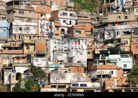 'Some giant photographes of a woman's eyes cover the walls of homes in Providencia slum in Rio de Janeiro, Brazil, on August 16, 2008. A French photographer who identifies himself as JR is exhibiting portraits of women whose loved ones were killed by police as part of his project entitled '28 mm'. 'Morro da Providencia' is one of the most dangerous favela in Rio de Janeiro. From some days, the facades of the poor houses of this slum watch to the city with great eyes that worry and observe the people walking down the hill. The eyes belong to the photographic project of JR, www.jr-art.net, a Fre Stock Photo