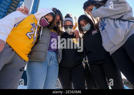 Los Angeles, California, USA. 26th Jan, 2021. Fans pray in front of a makeshift memorial honoring NBA star Kobe Bryant and his daughter Gigi near Staples Center in downtown Los Angeles, Tuesday, Jan. 26, 2021. Credit: Ringo Chiu/ZUMA Wire/Alamy Live News