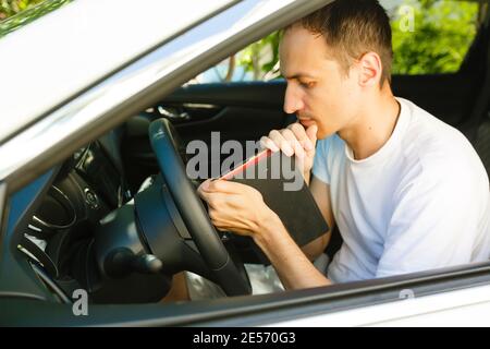 man prays with a bible in a car Stock Photo