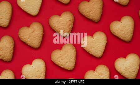 Valentine's Day and Mother's Day banner concept.Pattern of traditional homemade cookies, lots of heart shaped shortbread cookies on red background, to Stock Photo