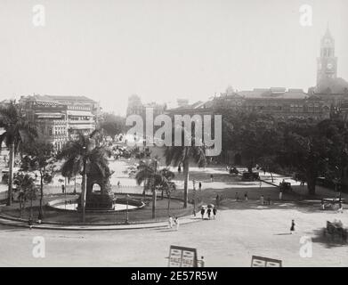 19th century vintage photograph: street view Bombay, Mumbai, India. Flora Fountain is located at the Hutatma Chowk is an ornamentally sculpted architectural heritage monument located at the southern end of the historic Dadabhai Naoroji Road.