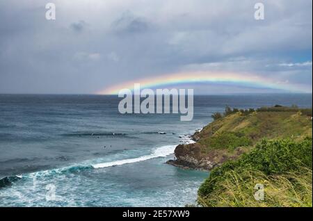 Rainbow over ocean at Honolua Bay on Maui. Stock Photo