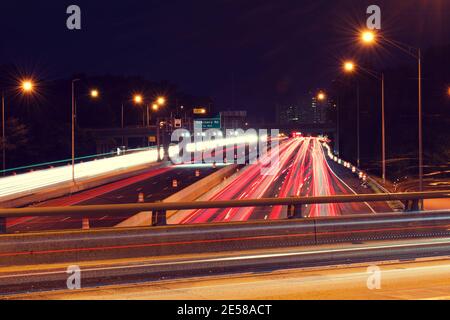 Light trails from vehicles traveling on the interstate 395,  view of the highway from overpass road. Stock Photo