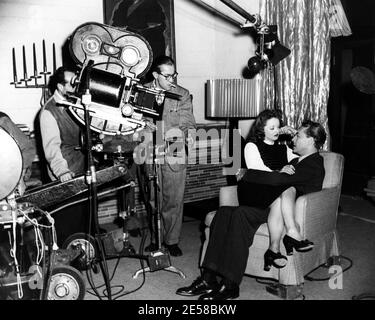 1946 , USA: The movie actress   BETTE  DAVIS (  1908 - 1989 ) and PAUL HENREID doing a scene for   DECEPTION  ( Il prezzo dell' inganno ) at Burbank  Warner Bros Studios under the watchful eye of director Irving Rapper   - CINEMA - FILM - attrice - portrait - ritratto - embrace - abbraccio - sul set - regista cinematografico -    ----  Archivio GBB Stock Photo