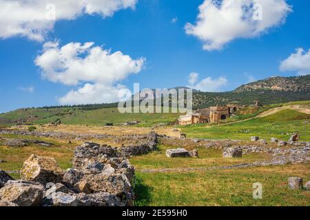 The ruins of the ancient city of Hierapolis at pamukkale, In the summer there are green grass and red flowers all over the area. This is an important Stock Photo