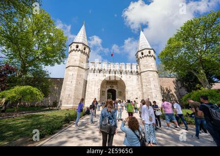 Istanbul / Turkey - May 02 2019 : The high walls and gates of the Topkapi Palace have many tourists. In summer, green trees with blue skies Stock Photo