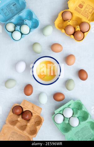 Different types of free range eggs with raw eggs in a bowl and shells on a white background Stock Photo