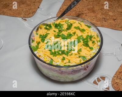 Dressed herring, colloquially known as herring under a fur coat, is a Russian layered salad composed of diced pickled herring covered with layers of g Stock Photo