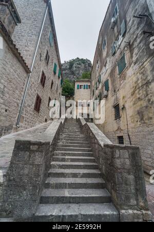 Old stone stairs leading high behind Kotor into the Fortress that winds up along Lovcen mountain and views of Kotor Bay. Stock Photo