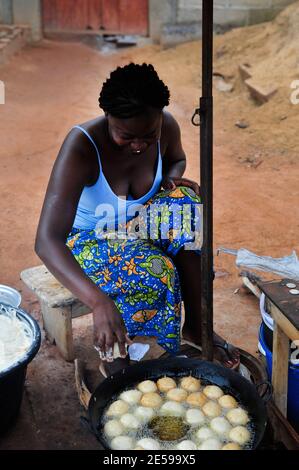 A Burkinabe woman deep frying gateaux ( fried doughnuts ). This is a popular breakfast in Burkina faso and west Africa. Stock Photo