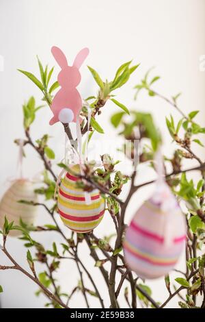 Easter eggs hanging on a spring blossom branch. Easter decorations. Birch tree branches decorated with bright painted eggs. Postcard. Selective focus Stock Photo