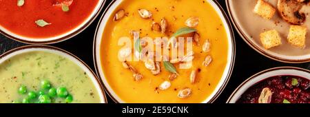 Vegan soup panorama. An assortment of vegetable soups, shot from the top on a black background Stock Photo