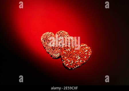 Valentine's Day candies on red black background. Red candy hearts with space for text Stock Photo