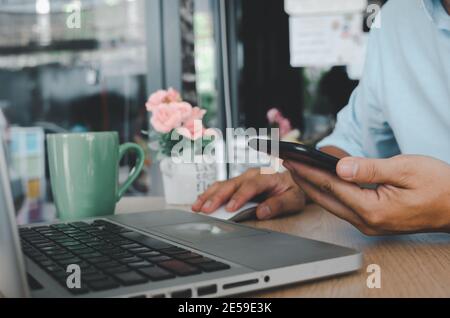 business man hand using mobile smart phone and mouse computer laptop on table.searching internet technology. Social media online business concept Stock Photo