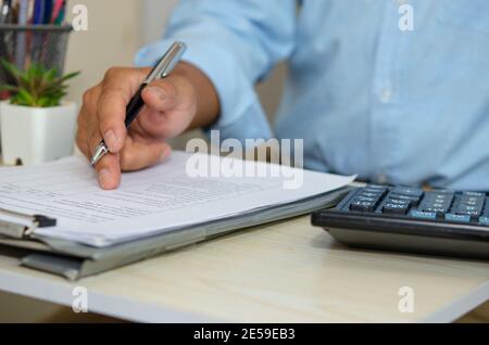 Business men look at business documents and hold pens at desk. Work from home Stock Photo