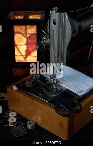 Sewing machine and parts on a dark background Stock Photo