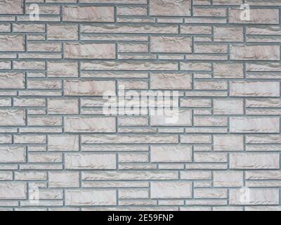 Wall with neatly laid out textured granite masonry of various shapes and sizes Stock Photo