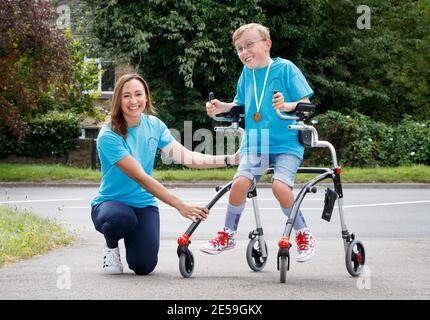 File photo dated 01/08/2020 of Tobias Weller, who has cerebral palsy and autism, alongside Olympic athlete Jessica Ennis-Hill, after he completed his challenge to run a marathon in a street near his home in Sheffield, using a race runner. Tobias, who cannot stand or walk unaided, was inspired by Captain Tom Moore to complete his first marathon on his daily walks back in April. Saturday January 30 marks the one year anniversary of the earliest known death from coronavirus in UK. Issue date: Wednesday January 27, 2021. Stock Photo