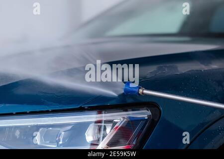 Close up of washing the car with high pressure water at self service car wash. Stock Photo