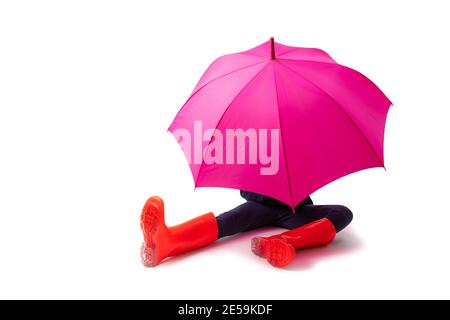 Person wearing red rubber shoes and rain umbrella isolated on white background. Stock Photo