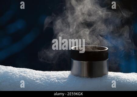 Thermos With A Steaming Mug Of Hot Drink Stands In The Snow Winter