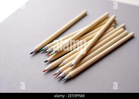 Eco-friendly pencils on a gray background. Colored recyclable crayons. Several colored pencils lie on gray paper. Stock Photo