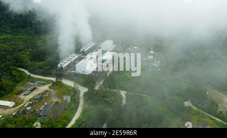 Aerial drone of Geotermal power plant on Mount Apo. Geothermal station with steam and pipes in the rainforest. Mindanao, Philippines. Stock Photo