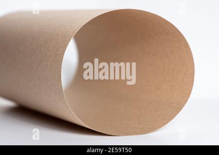 Beige paper roll on white background. Macro shot. Abstract background. Copy space. Stock Photo