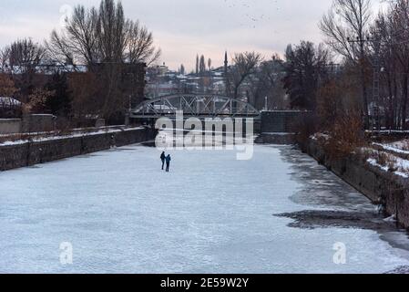 Two boys are walking on the frozen lake in Kars center.