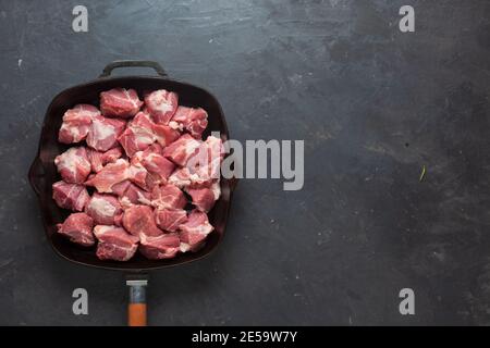 Heap small pieces raw meat in frying pan, top view Stock Photo