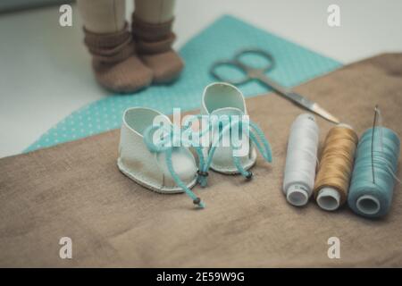 on the table lay a pair of scissors thread fabric for patchwork shoes and doll crafts classes quarantined Stock Photo