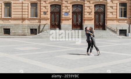 Valentines day celebration and dating outdoor concept. Happy loving couple dancing on the city street. Romantic couple spending time together in the Stock Photo