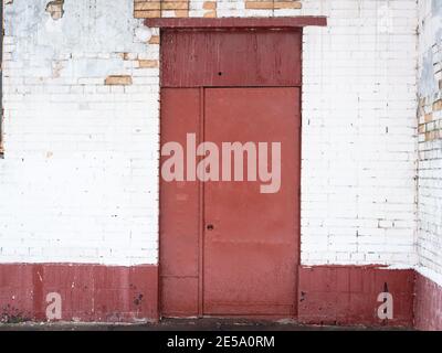 red painted metal door in white colored brick wall of house Stock Photo