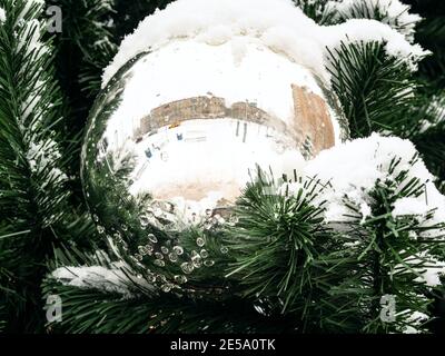 mirrored ball on outdoor Christmas tree close up on overcast winter day Stock Photo