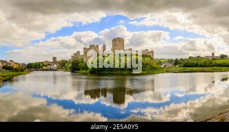 Panoramic view of Pembroke Castle (Castell Penfro) in Pembroke, county town of Pembrokeshire, south west Wales, UK reflected in water in the moat Stock Photo