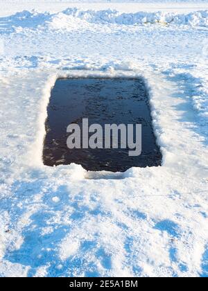 large swimming ice-hole in in frozen river on cold sunny winter day Stock Photo