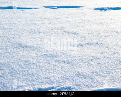 blue surface of fresh snow illuminated by setting sun in cold winter twiligh Stock Photo