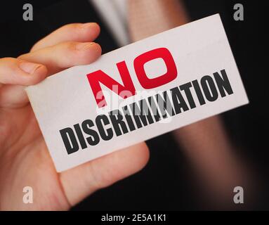 No discrimination words on a card in businessman hand. Social concept against racial and gender discrimination at work Stock Photo