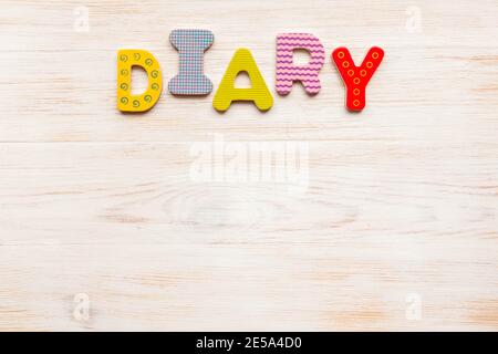 Word diary made of colorful wooden letters on vintage wood background. Copy space. Flat lay. Top view. Old blog tradition concept Stock Photo