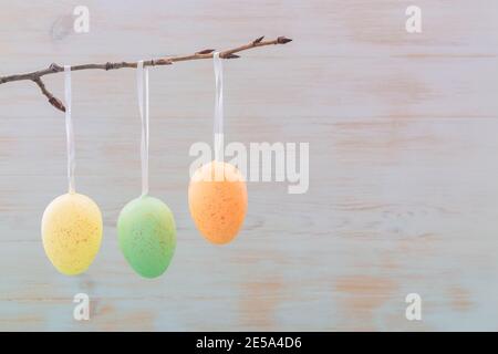 Easter eggs on branch in sping on wooden vintage background. Subtle gentle colored Eastern decoration. Easter mood. Minimalism. Copy space. Stock Photo